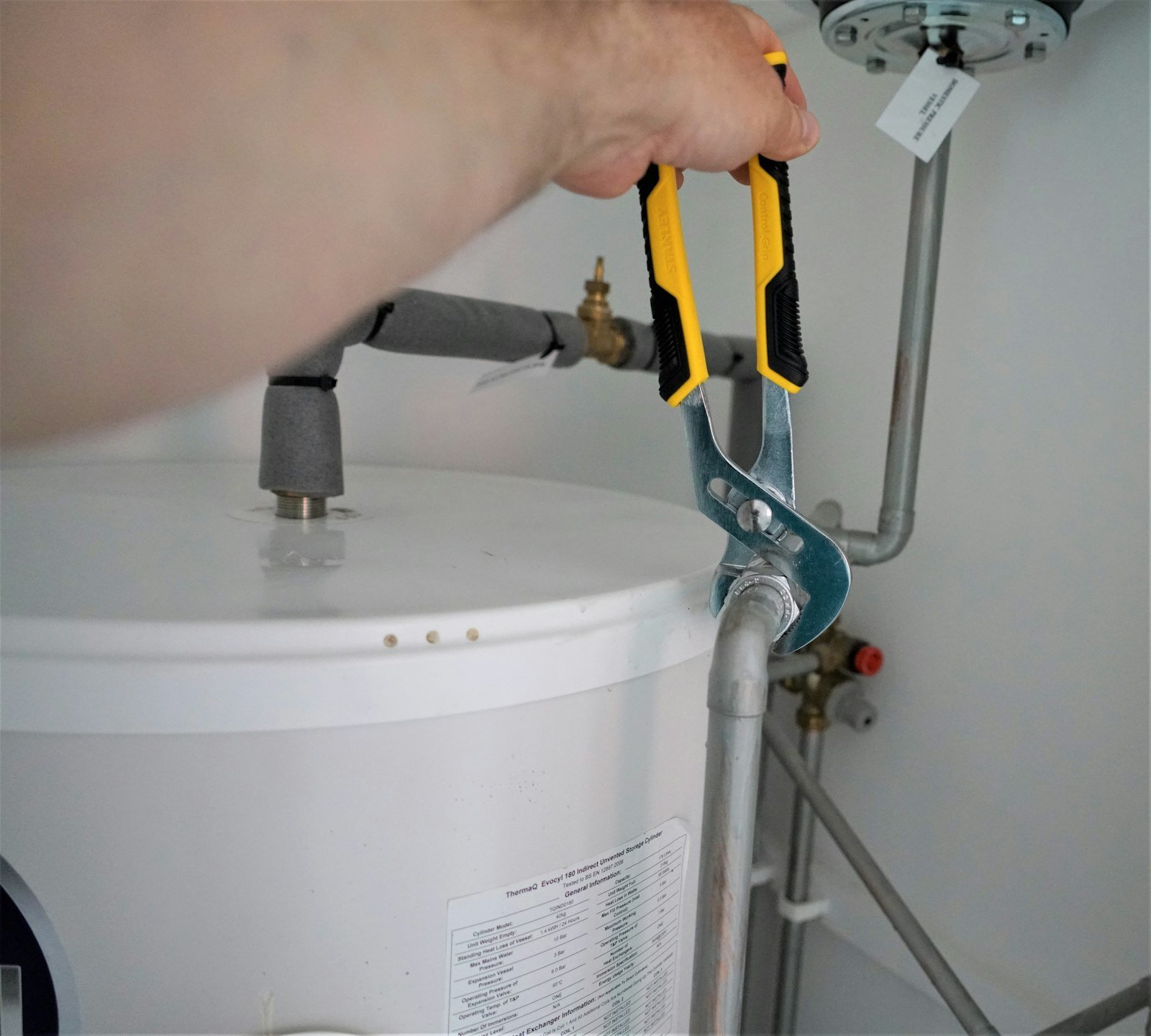 Checking a water heater tank's fittings and drain line for attic safety