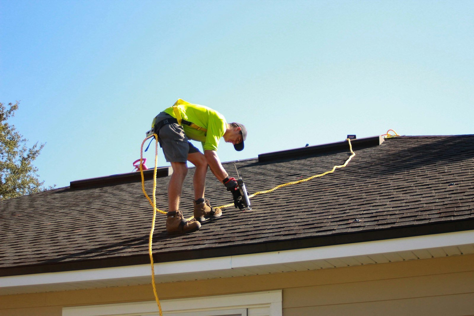 Technician on a residential roof checking for the source of a leak